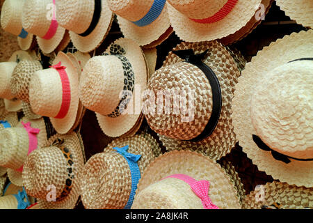 Many of women straw hats for beach vacation hanging on the rack Stock Photo