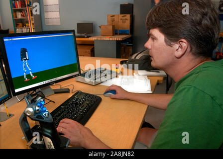 Research scientist Jerry Pratt analyzes the walking pattern of M2V2, a bipedal robot at the Institute for Human and Machine Cognition in Pensacola. Stock Photo