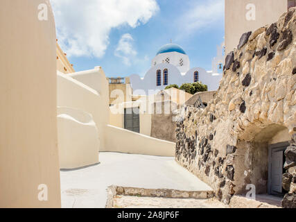 Street view of village Pyrgos and blue dome church on island of Santorini, Greece in Europe. Stock Photo