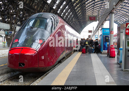 'Frecciarossa', a high-speed Italian train, poised at the Milan Central Station, a major railway hub in Northern Italy.
