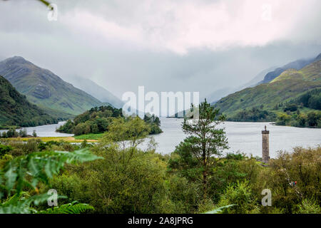 Glenfinnan monument in Scotland, Lochaber area, surrounded by beautiful valley on cloudy summer day. Stock Photo