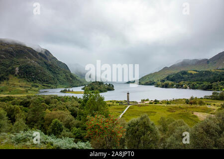 Glenfinnan monument in Scotland, Lochaber area, surrounded by beautiful valley on cloudy summer day. Stock Photo