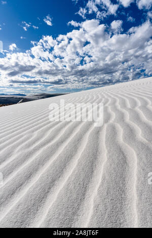 Ripples in a white sand dune against a blue sky background at White Sands National Monument, New Mexico, USA Stock Photo