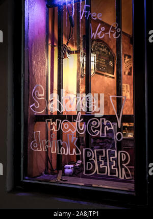 Beer advertisement on a window of a restaurant, in front of it a laid ...