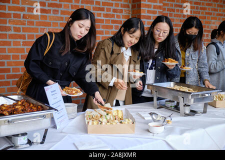 Foreign students getting food from buffet catering at The Great Hall of Queen's University in Belfast. Stock Photo