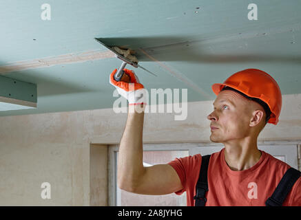The worker is filling the  plasterboards seams the gypsum putty. Stock Photo