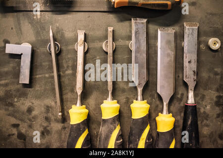 Carpenter tools composition. Old carpenter chisels on special magnetic board Stock Photo