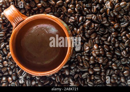 Empty Mexican clay mug and dark roasted coffee beans. Background and frame for text. Useful for coffee shops, cafe, menu, etc. Stock Photo