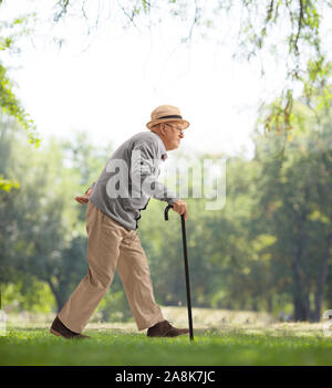 Full length profile shot of a senior man walking with a cane in a park Stock Photo