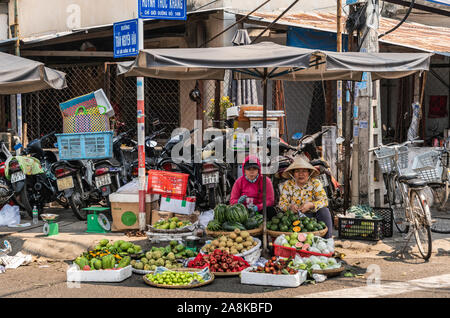Nha Trang, Vietnam - March 11, 2019: Duong Huynh Thuc Khang market. 2 women sell freshly harvested fruit in small quantities on corner of street. Bunc Stock Photo
