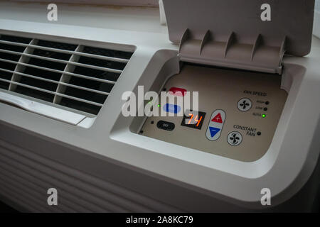 north american temperature control panel attached to the air conditioner unit in an old hotel room display 74F Stock Photo