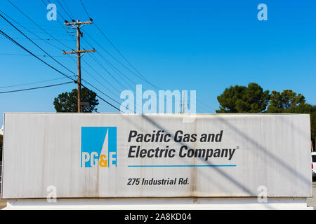 Weathered PG&E, Pacific Gas and Electric Company, sign and logo near customer service center. Overhead power line on wooden utility pole Stock Photo