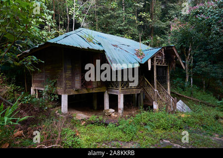 Looking at an abandoned, rotting cottage near the waterfall at Gunung Stong State park. In DaBong, Kelantan, Malaysia. Stock Photo