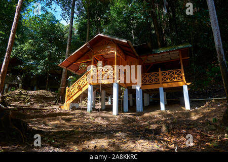 Looking at a restored, yellow cottage near the waterfall at Gunung Stong State park. In DaBong, Kelantan, Malaysia. Stock Photo