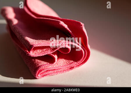 a pink nonwoven cloth lying in the windowsill as the sun goes down Stock Photo