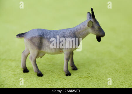 plastic toy animal, a goat on green background Stock Photo