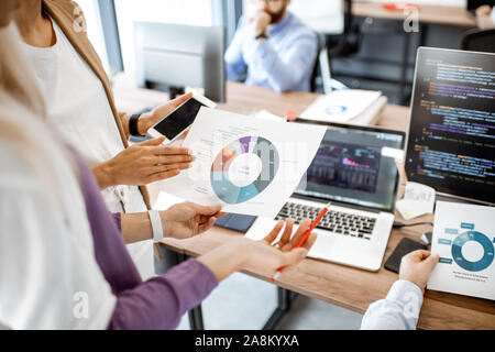 Programmers making financial analysis, working with programming code in the office, close-up on the paper chart Stock Photo
