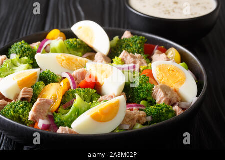 Healthy salad with tuna, broccoli, tomatoes, onions and eggs close-up in a plate on the table. horizontal Stock Photo