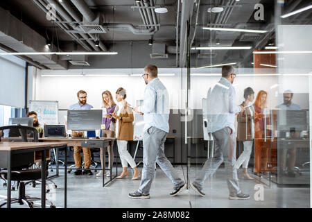 Interior view on the modern office room with diverse people working on the computers indoors Stock Photo