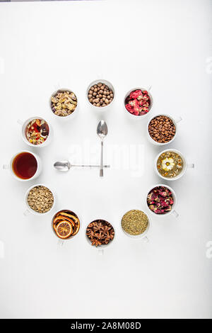 A concept or creative idea that means tea time. Useful herbal or green tea in the center and around the various dried herbs for its preparation. Stock Photo