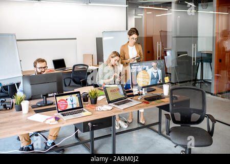 Modern office room of web designers with working places and people working Stock Photo