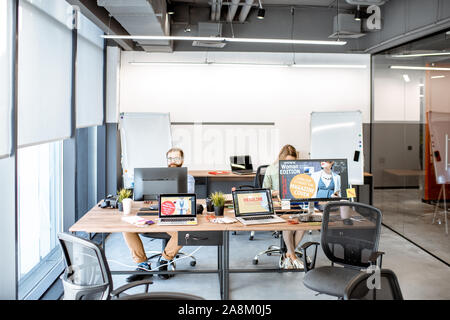 Modern office room of web designers with working places and people working Stock Photo