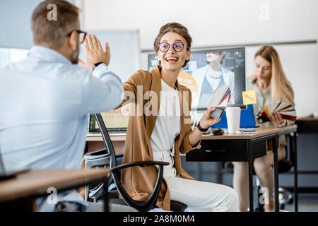 Group of creative and happy coworkers working on web design with computers in the office Stock Photo