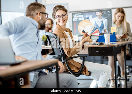 Group of creative and happy coworkers working on web design with computers in the office Stock Photo