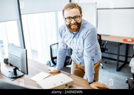 Portrait of a handsome bearded office worker dressed casually during a work in the office Stock Photo