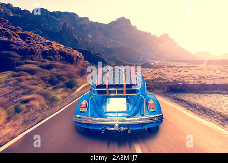 Retro car with luggage on the roof rack on the mountain road. Travel, vacation concepts.retro, vintage color Stock Photo