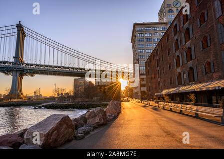 Manhattan Bridge in Backlight, Morning Sun, Sun Star, Sunrise, Empire Fulton Ferry Park, Dumbo, Brooklyn, New York, USA Stock Photo