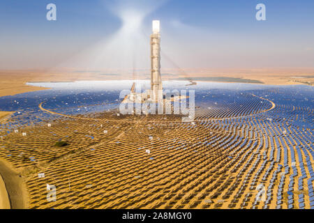 Solar power plant mirrors that focus the sun's rays upon a collector tower to produce renewable, pollution-free energy - Aerial image. Stock Photo