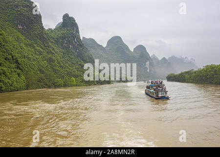 Editorial: GUILIN, GUANGXI, CHINA, April 19, 2019 - River cruise boats navigating in convoy on the Li River near Guilin Stock Photo