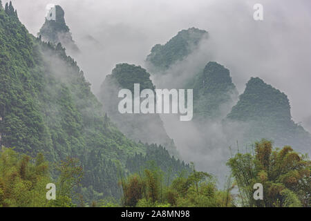 Dense clouds rising along the hills near Yangshuo on the Li River near Guilin Stock Photo