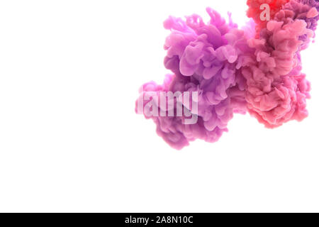 Mix of abstract red and violet ink in water on a white background. It looks like smoke or cloud. Or zero gravity. Stock Photo