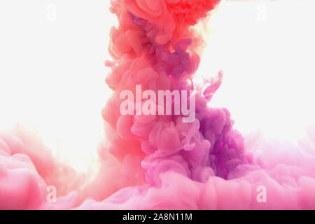 Mix of abstract red and violet ink in water on a white background. It looks like smoke or cloud. Or zero gravity. Stock Photo