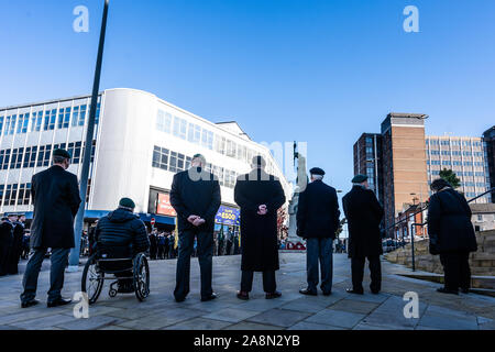 War veterans including one in a wheelchair attend the Remembrance parade and stand at ease, at to attention during the ceremony, Stock Photo
