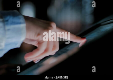 Woman using interactive touchscreen display at modern history museum Stock Photo