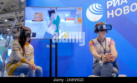 Two women using virtual reality headset and looking around Stock Photo