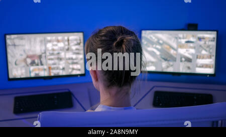 Woman security guard looking at modern cctv camera monitors Stock Photo