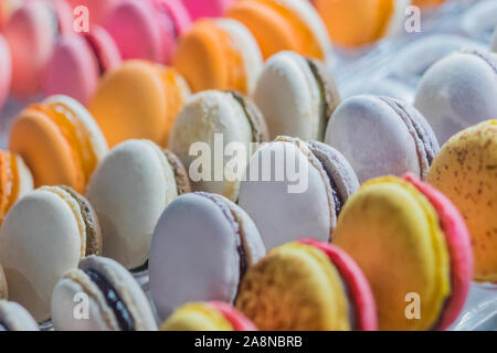 Rows of bright colorful macarons on counter of candy shop Stock Photo