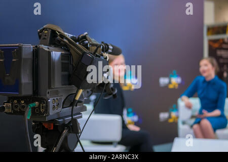 Television video camera recording interview in broadcast news studio Stock Photo