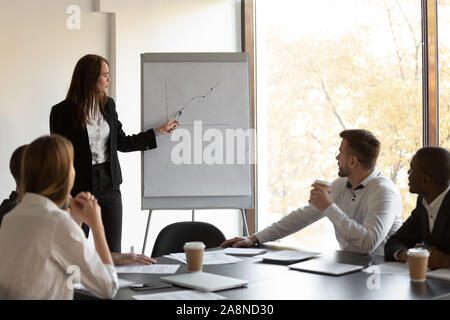 Female financial advisor making whiteboard presentation at briefing Stock Photo