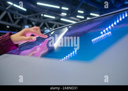 Woman using multimedia touchscreen display of interactive kiosk Stock Photo