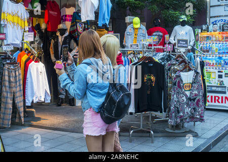 Osaka, Japan - November 2nd, 2019: Two Japanese fashionable girls taking selfie in the streets. Stock Photo