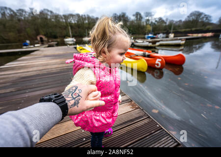 A pretty little girl enjoys a day out at Rudyard lake with her Dad, father in Leek on the Staffordshire, Derbyshire border by the Peak District Stock Photo
