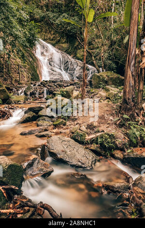 Beautiful tropical landscape with a cascade waterfall in jungle forest Stock Photo