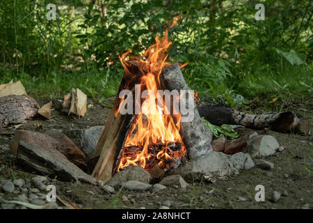 Campfire bonfire logs burning in a stone circle Stock Photo