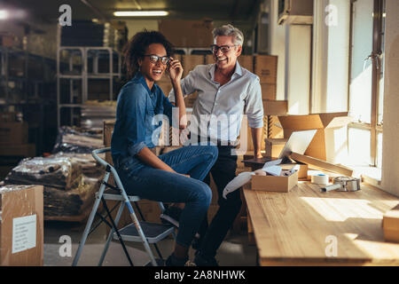 Successful online shop business partners in office. Male and female entrepreneurs at online store warehouse looking at camera and smiling. Stock Photo