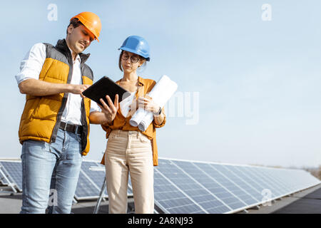 Two engineers or architects examining solar power plant with a digital tablet. Solar station development concept Stock Photo
